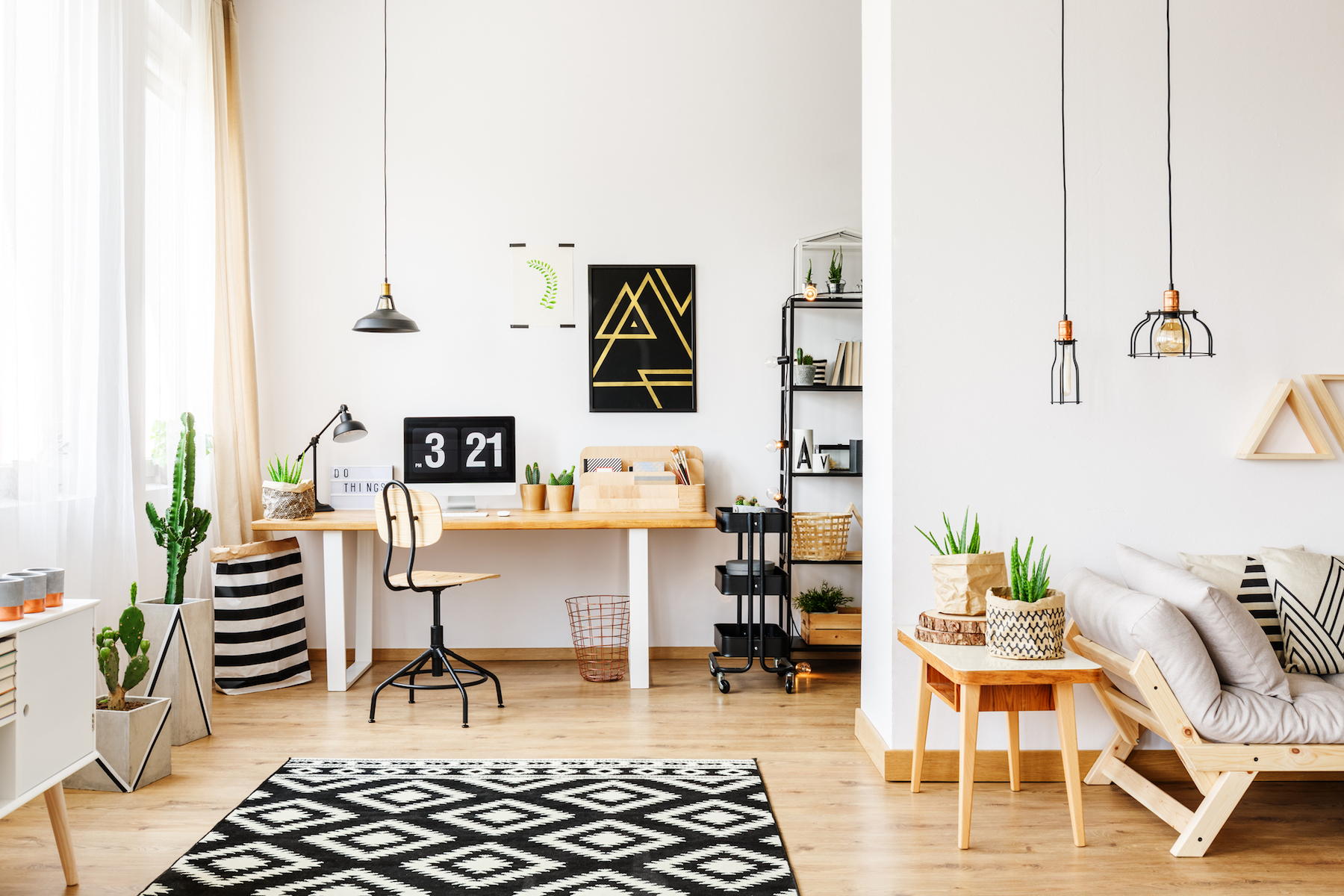 Black and white geometric carpet in multifuncional workspace with painting on wall above desk